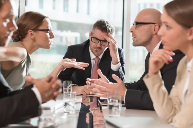 Personas discutiendo en una sala de reuniones.