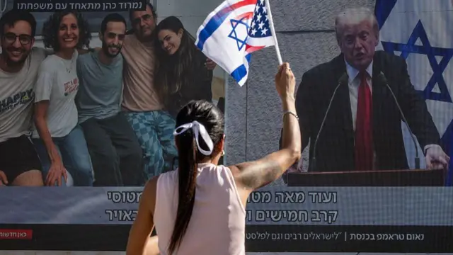 Pantalla en plaza de Tel Aviv muestra a Trump y la liberación de los rehenes.