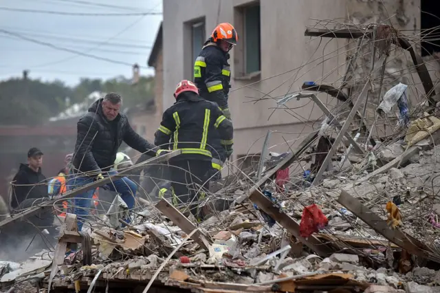 Rescatistas ucranianos entre los restos de una casa cerca de la ciudad de Lviv, al oeste de Ucrania.