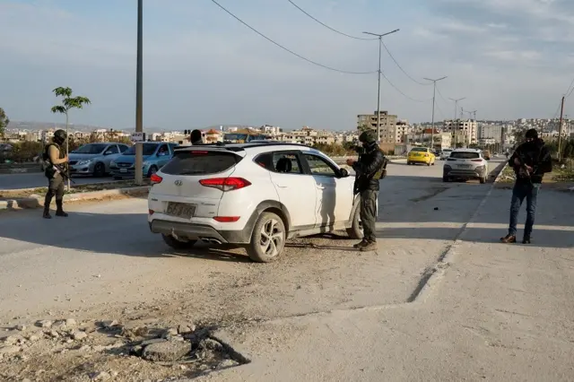 Agentes de seguridad palestinos al lado de un vehículo blanco