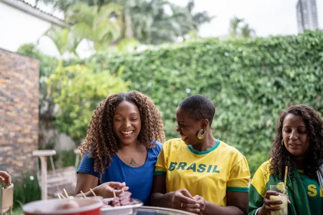 Tres mujeres disfrutan una barbacoa en Brasil.