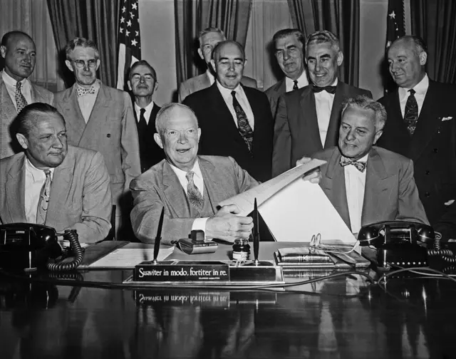 El presidente estadounidense Dwight Eisenhower sostiene el proyecto de ley de energía atómica, muy debatido, después de firmarlo en la Casa Blanca el 31 de agosto de 1954.
