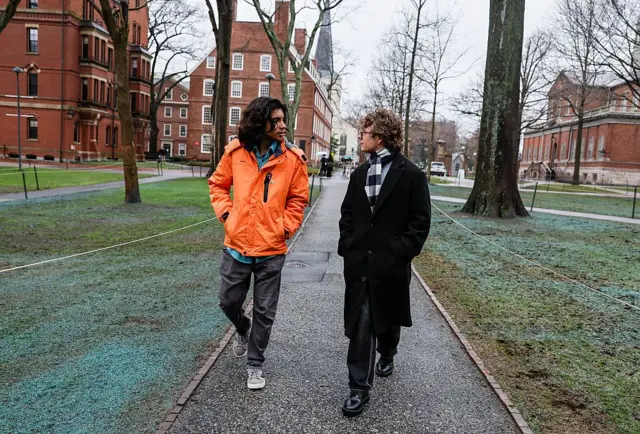 Dos estudiantes extranjeros caminan por el campus de la Universidad de Harvard