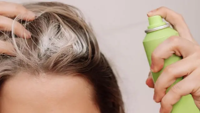 Mujer utilizando champú seco