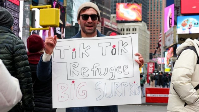 Un hombre en Nueva York sostiene una pancarta que dice 