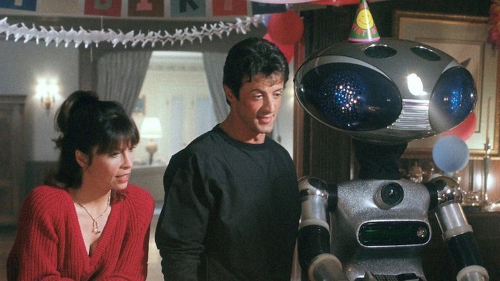 De izquierda a derecha: Adrian Pennino (Talia Shire), Rocky Balboa (Sylvester Stallone) y el robot SICO en el cumpleaños de Paulie en Rocky IV. Foto: MGM