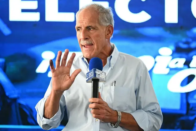 Nesry Asfura habla con un micrófono en la mano en un mitin de su campaña