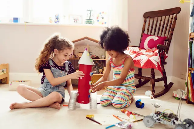 Dos niñas jugando con un cohete.