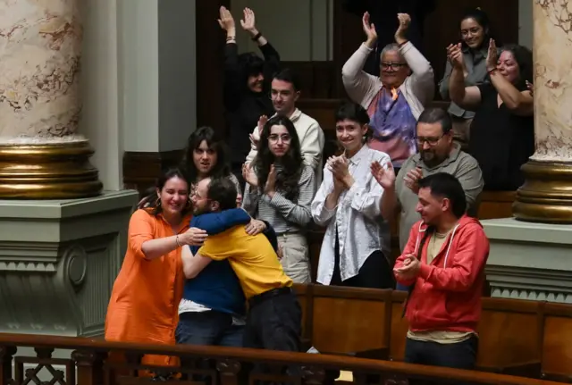 Florencia Salgueiro en el Congreso se abrazo con otras personas mientras hay aplausos por la aprobación de la ley de eutanasia en Uruguay el 15 de octubre de 2025
