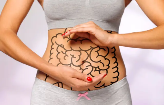 Una mujer con un intestino dibujado en su panza