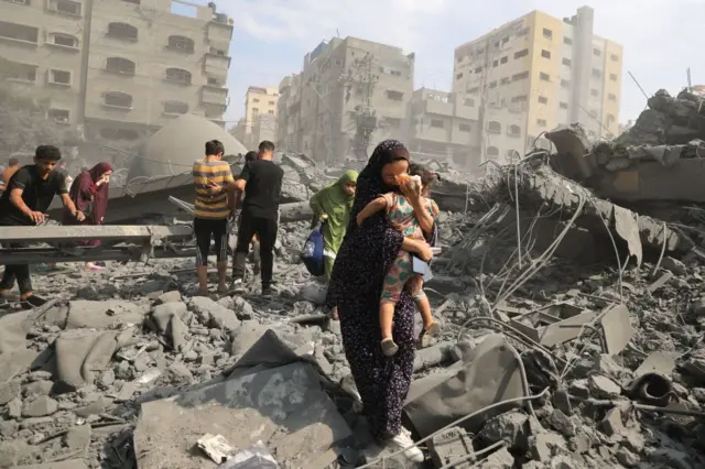 Mujer camina por los escombros en los territorios palestinos.