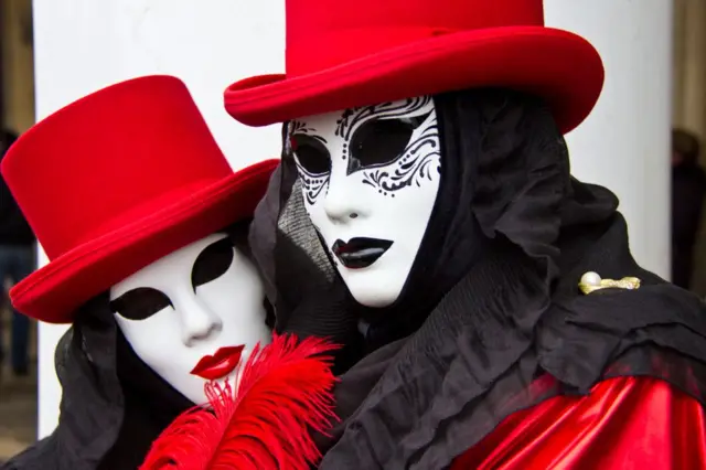 Dos personas con máscaras