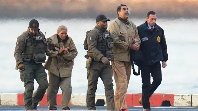 Nicolás Maduro y su esposa, Cilia Flores, esposados ​​después de aterrizar en un helipuerto de Manhattan, escoltados por agentes federales.