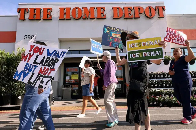 Activistas anti-ICE marchan frente a Home Depot en Pasadena con la esperanza de que la tienda proteja a los trabajadores temporales en la instalación el 6 de agosto de 2025. Los activistas han estado en el lugar con la esperanza de disuadir a ICE de secuestrar a los trabajadores temporales. (Genaro Molina/Los Angeles Times vía Getty Images)