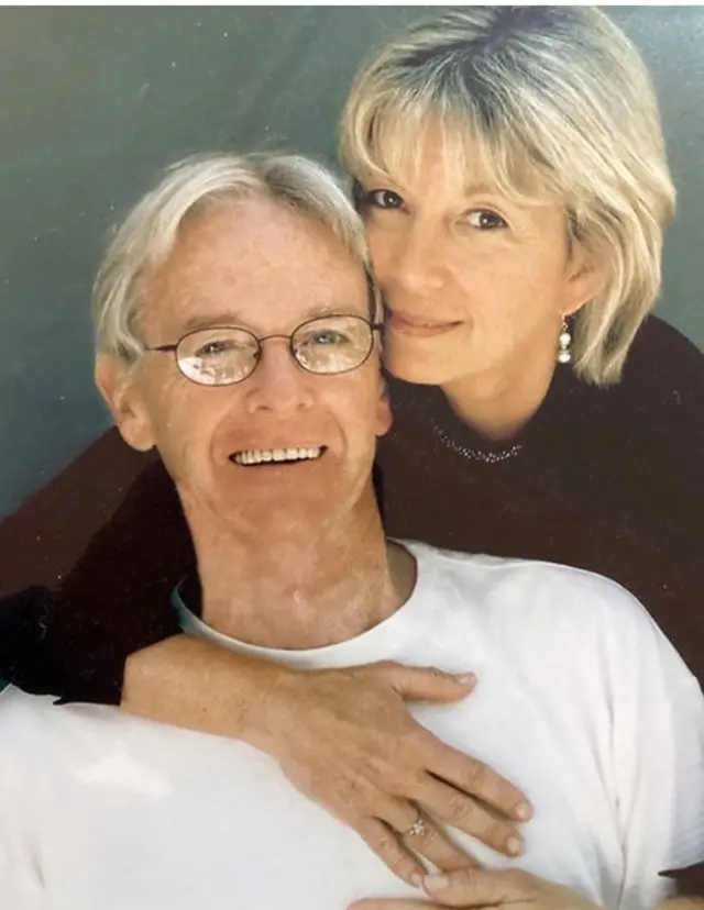 Chuck y Daphne posan sonrientes. Daphne abraza a Chuck por la espalda, posándole una mano en el pecho en la que se puede apreciar su anillo de compromiso. Él lleva una camiseta de manga corta blanca y ella un jersey negro.