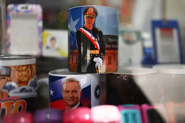 Una taza con la imagen de Augusto Pinochet se apoya sonbre otra con el rostro de José Antonio Kast en un comercio de Santiago de Chile. 