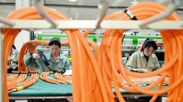 Trabajadoras en una planta de fabricación de autos eléctricos en China