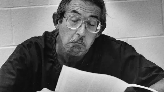 Aldrich Ames en una fotografía en blanco y negro en la que se le ve leyendo un papel.