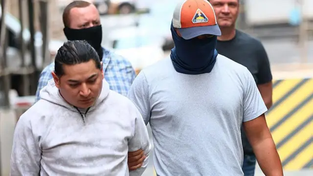 Agentes enmascarados detienen a un migrante en Nueva York.