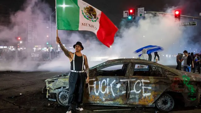 Un manifestante ondea la bandera de México en el barrio Compton de Los Ángeles.