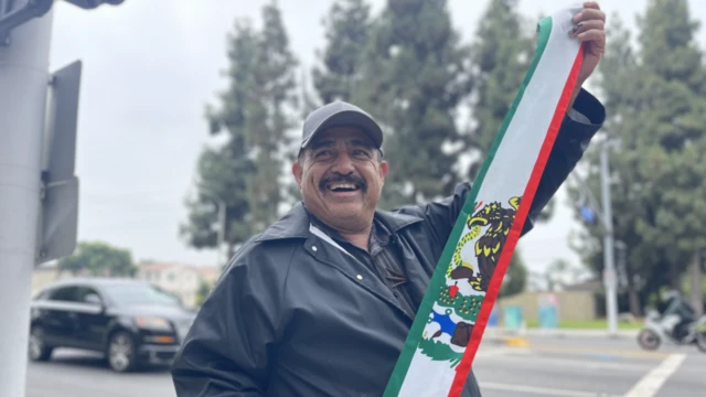 Un vecino nuestra la bandera mexicana en Paramount, Los Ángeles, Estados Unidos, el 8 de junio de 2025.