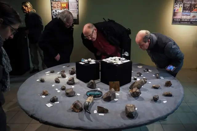 Un grupo de coleccionistas de meteoritos viendo unos trozos en Francia