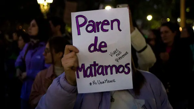 Una mujer con un cartel que dice 