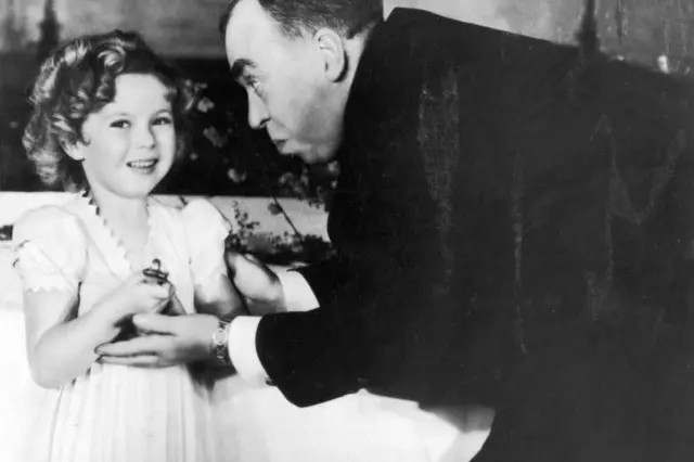 Shirley Temple recibiendo un Oscar especial de manos del guionista estadounidense Irwin S. Cobb en la ceremonia de los Premios de la Academia, en 1935.