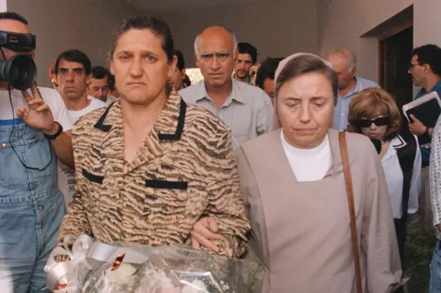 La monja Martha Pelloni toma del brazo a la madre de María Soledad. Su padre se ve atrás mirando a la cámara.