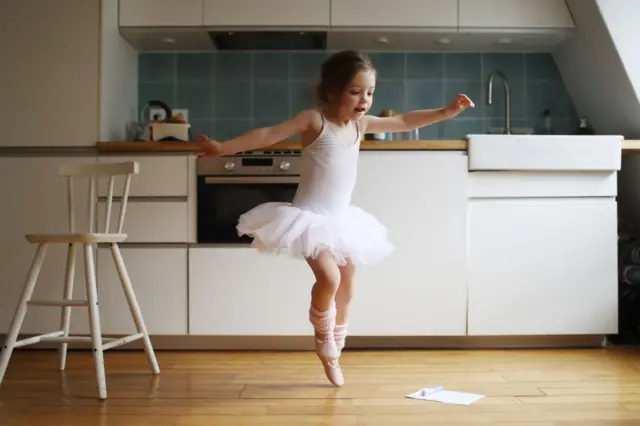 Una pequeña bailarina de ballet en la cocina
