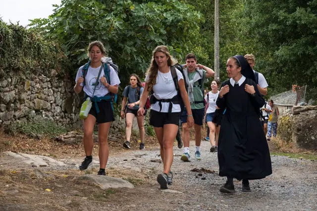 Un grupo de chicos y chicas junto a una religiosa de Schoenstatt hacen el camino de Santiago, en España.
