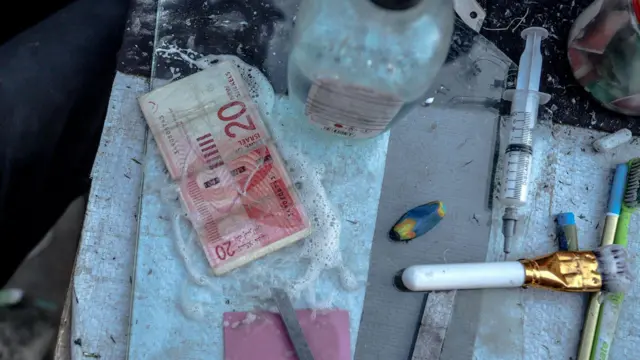 Un billete está siendo reparado en una pequeña mesa de madera. 