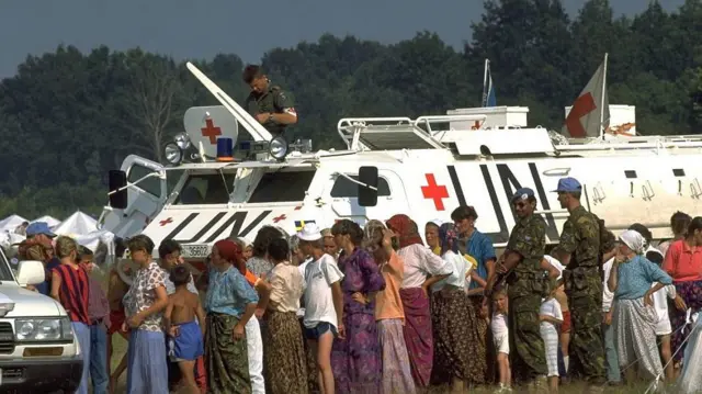 Un grupo de refugiados de Srebrenica junto a un blindado de Naciones Unidas en Tuzla en 1995.