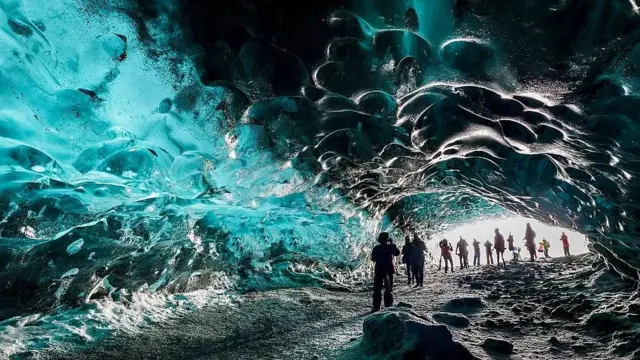 Turistas en la cueva de hielo de un glaciar en Islandia