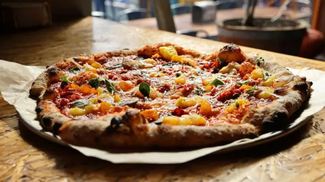 Una gran pizza redonda con salsa de tomate, ajo fresco, chiles, queso y aceite de oliva