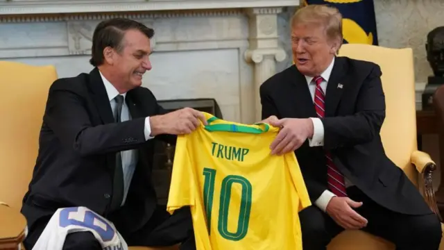Jair Bolsonaro le entrega la camiseta número 10 del equipo de Brasil -con el nombre Trump- al presidente de EE.UU. Donald Trump