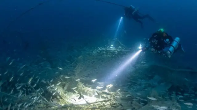 Dos buzos en el fondo del mar en busca de los restos del naufragio