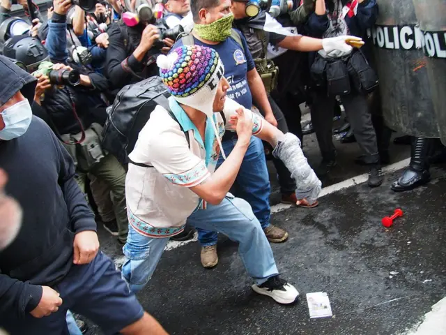Un indígena se enfrenta a un cordón de la policía en Lima en una protesta