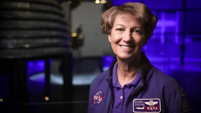 Eileen Collins con su uniforme de la NASA sonríe a la cámara