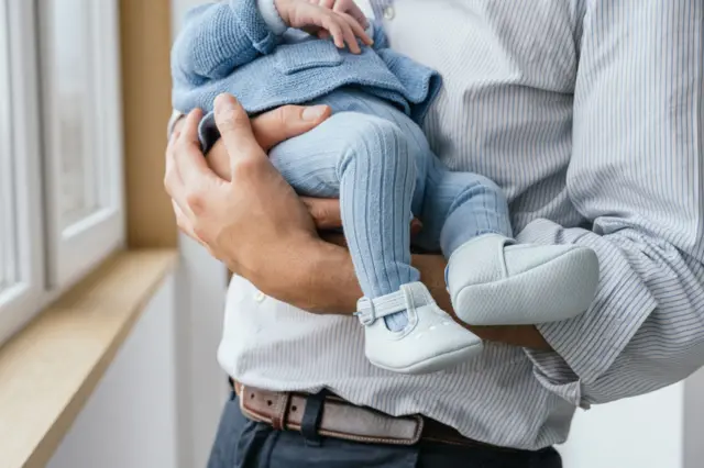 Un hombre sostiene a su hijo