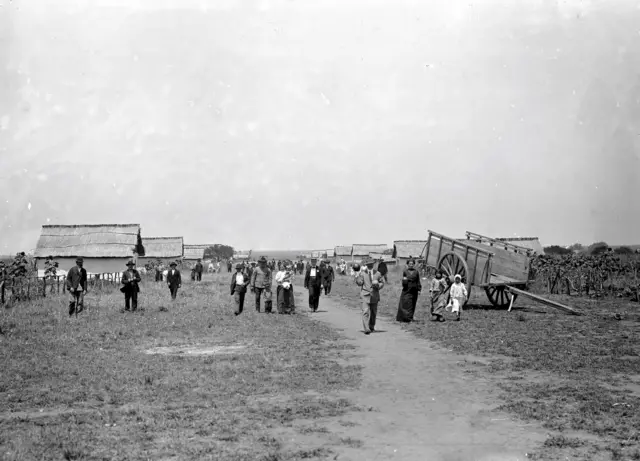 Personas, casas y carretas junto a un camino de tierra en San Javier poco después de la fundación del pueblo por inmigrantes rusos. 