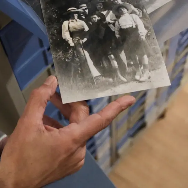 Una persona sostiene una vieja fotografía en blanco y negro