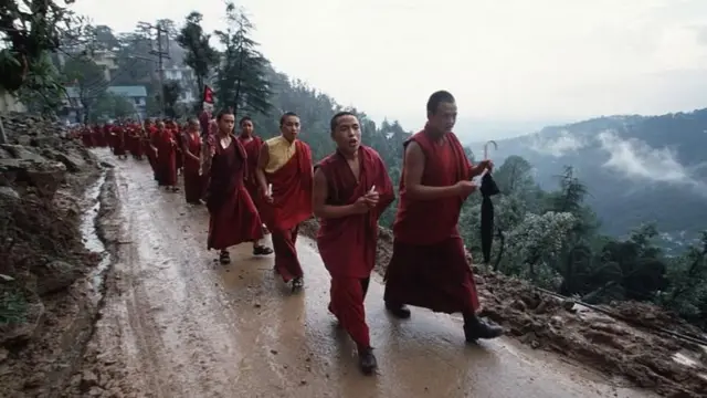 Monjes tibetanos caminan por una montaña