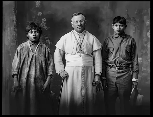 Retrato de Monseñor Sabas Sarazola junto a Eleuterio y Evangelino, machiguengas originarios ca. 1928. Negativo en soporte de vidrio tamaño 9 x 12 cm. Estudio calle Marqués nº 67 Cusco 