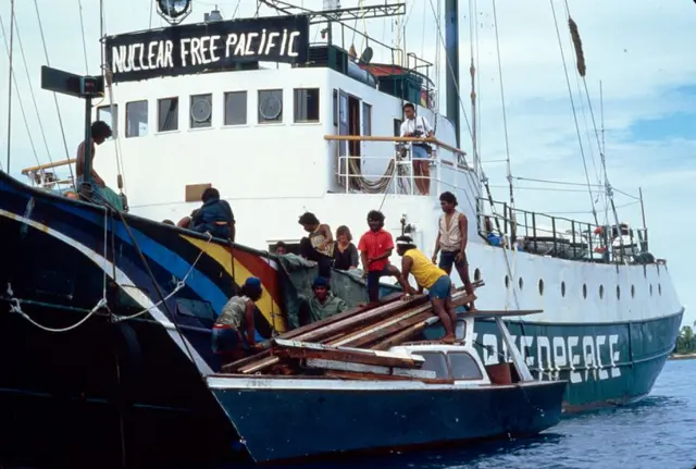 La tripulación del Rainbow Warrior ayudando a gente de Rongelap a subir a bordo. 