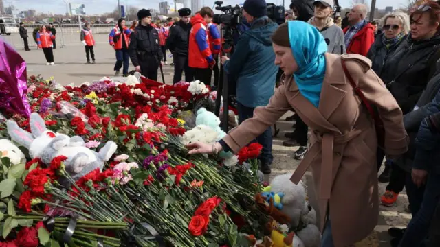 Una mujer coloca flores en un monumento conmemorativo a las víctimas del ataque al Crocus City Hall, cerca del Crocus City Hall, el 30 de marzo de 2024 en Krasnogorsk, Rusia.