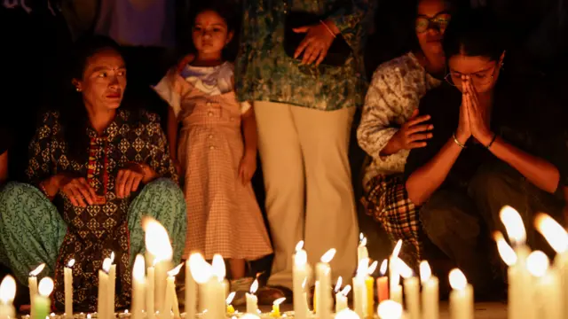 La gente participa en una vigilia con velas en memoria de las personas que murieron durante la protesta contra la corrupción provocada por la prohibición de las redes sociales.
