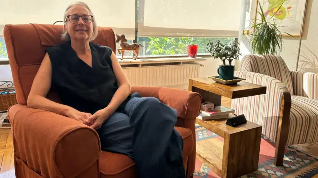 Gina Montaner, en la butaca en la que se solía sentar su padre, en su casa en Madrid. Julio de 2025