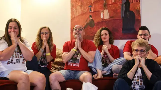 Seis familiares del rehén israelí Eitan Horn, algunos vistiendo camisetas rojas con su imagen que dicen