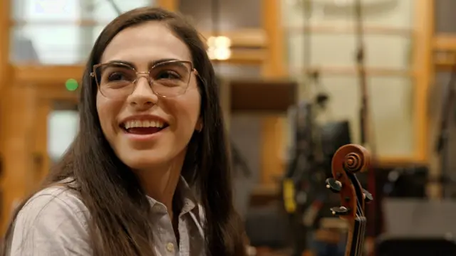 Pathrycia Mendonça sonríe mientras sostiene su violín